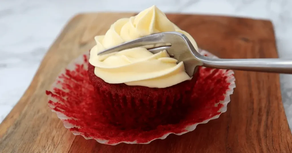 Delicious homemade red velvet cupcakes with creamy cream cheese frosting, garnished with chocolate shavings and fresh strawberries, perfect for special occasions and indulgent treats.