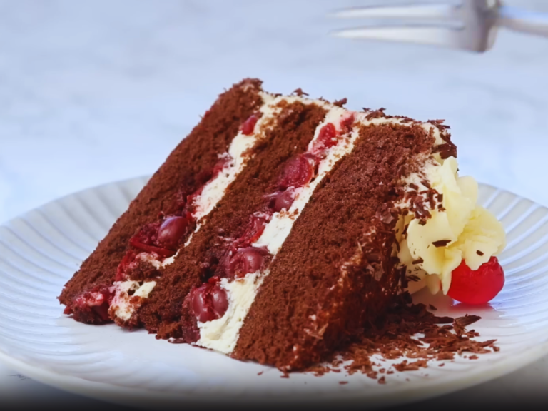 Decadent Black Forest Cake with layers of chocolate sponge, whipped cream, and cherries